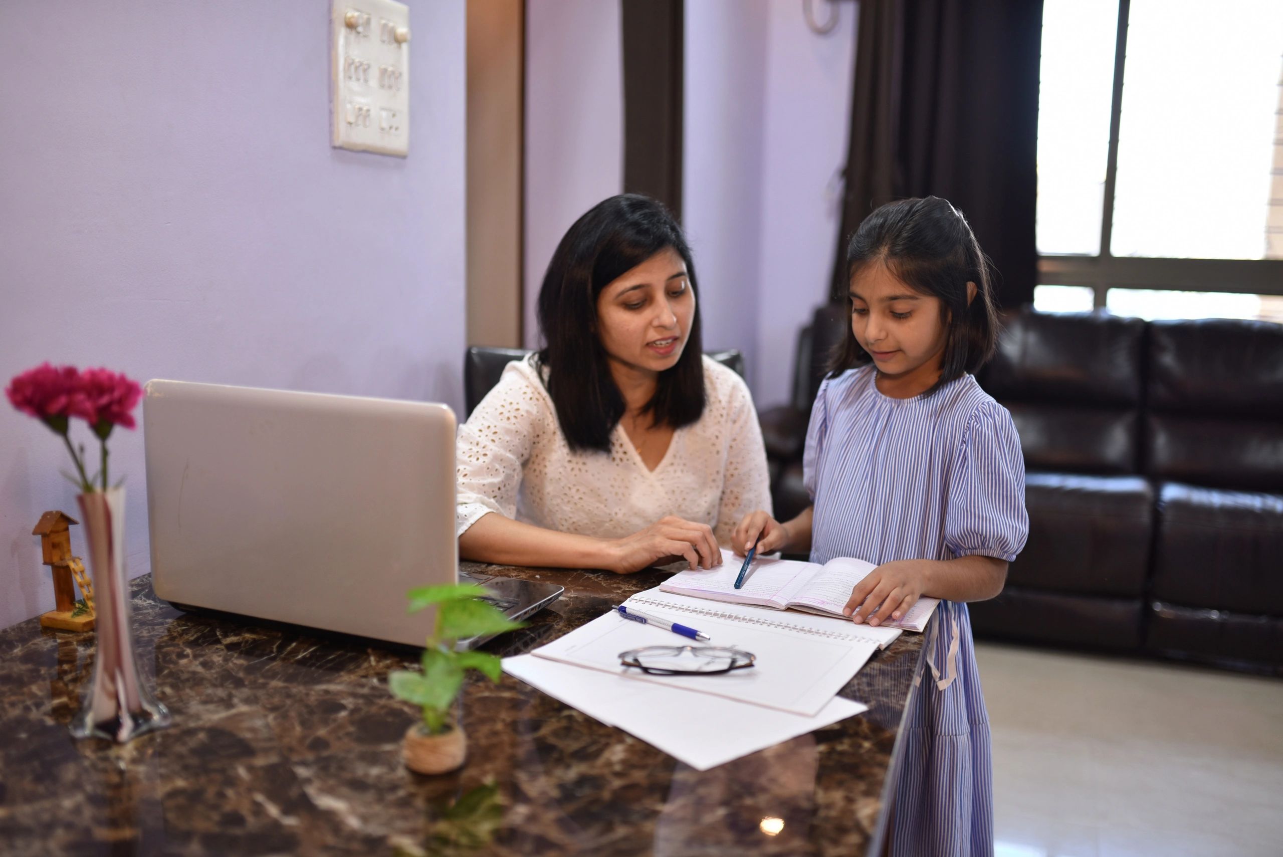 Mother helping daughter with homework at home