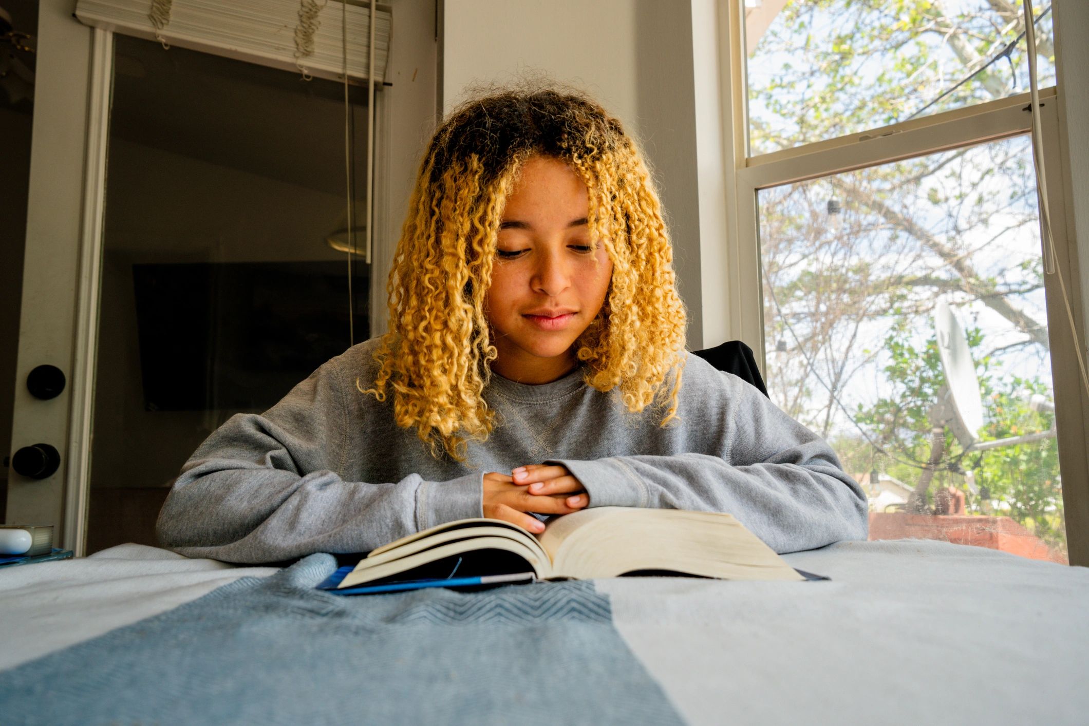 Student reading a book at a table