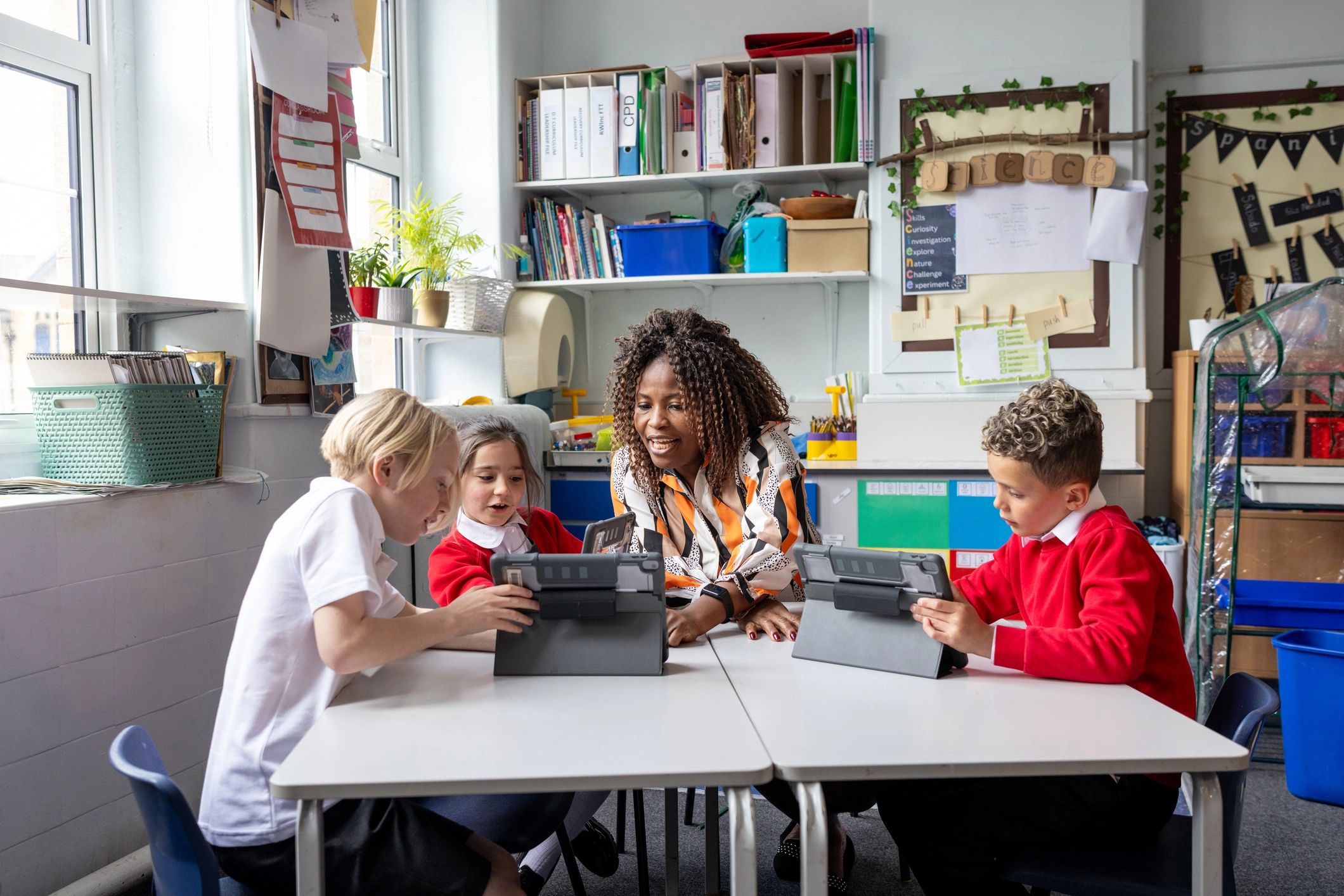 Teacher guiding students using digital tablets in a classroom