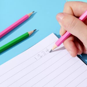 Pencils of various colors placed on a blue paper, children's learning stationery
