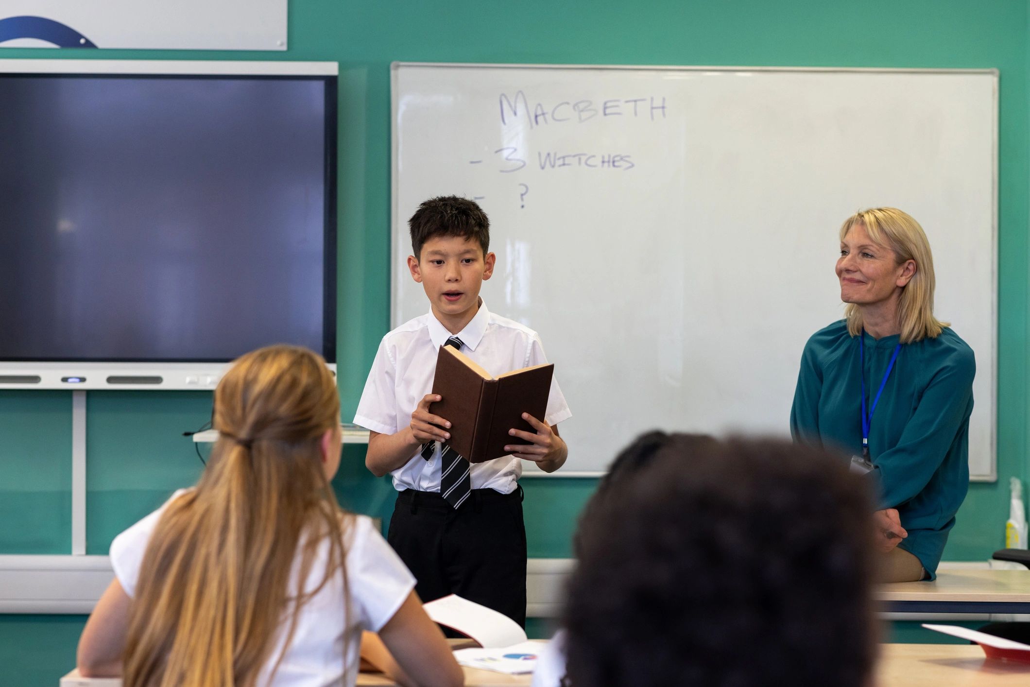 Boy reading aloud to classmates